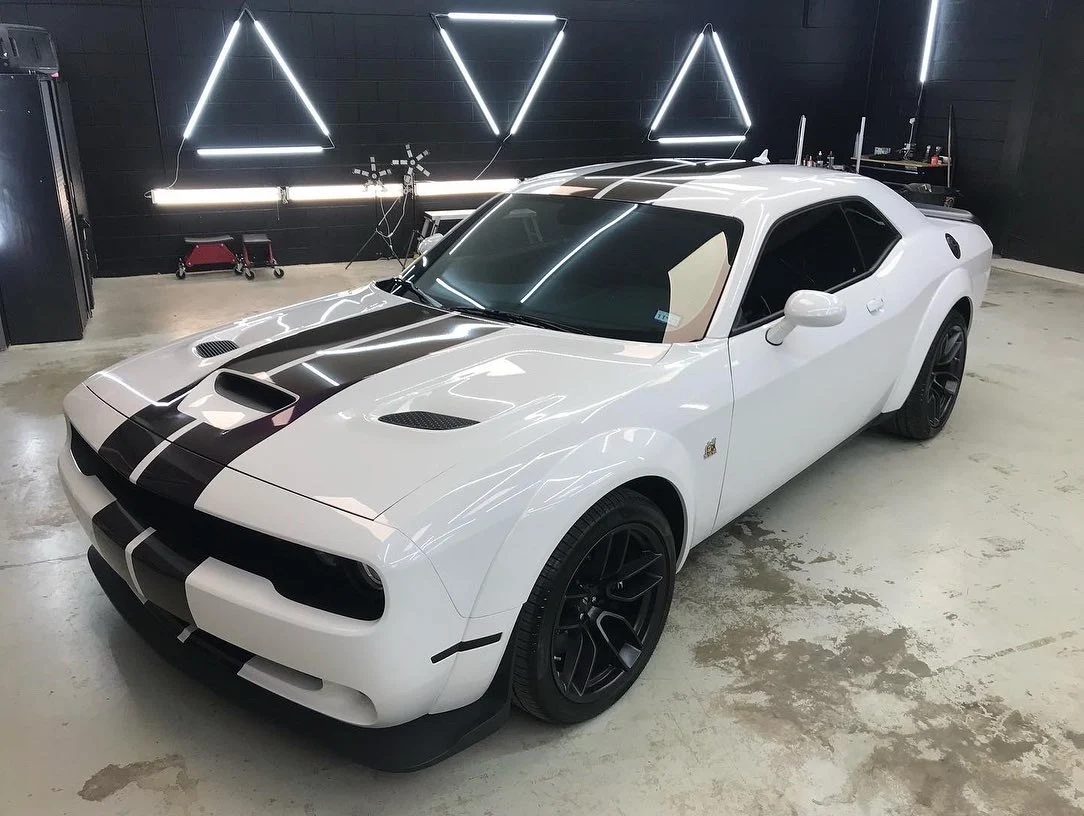 White Dodge Challenger Hellcat in Paint Slayer shop with LED lights